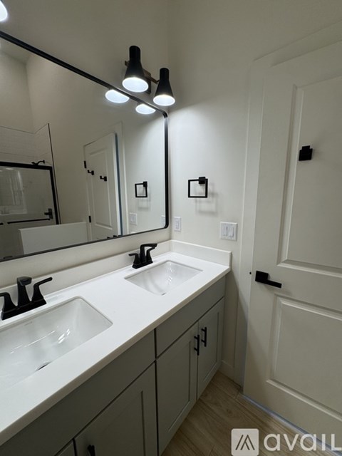 A bathroom with a white counter top and a mirror above it.