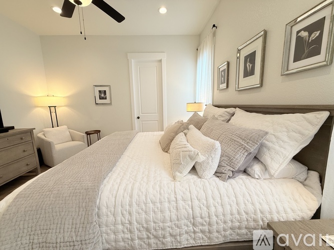 A bedroom with a large bed and a ceiling fan.