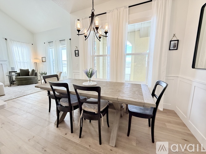 A dining room with a wooden table and chairs.