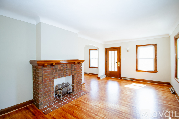 A living room with a fireplace and wood floors.