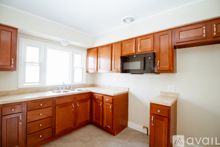 A kitchen with wooden cabinets and a microwave.