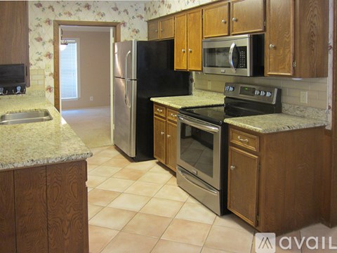 A kitchen with wooden cabinets and a black refrigerator.