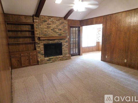 A living room with a fireplace and wooden floors.
