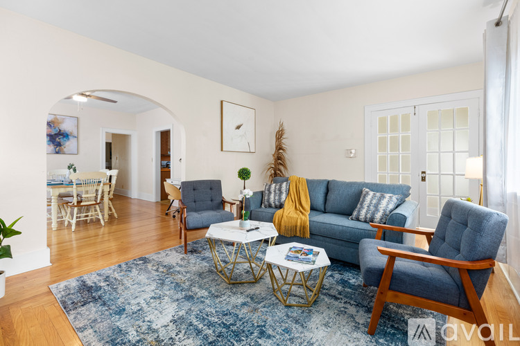 A living room with a blue rug and a grey sofa.