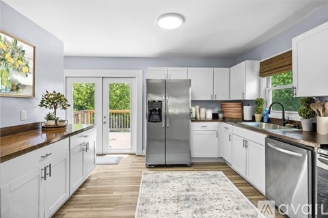 A kitchen with white cabinets and a stainless steel refrigerator.