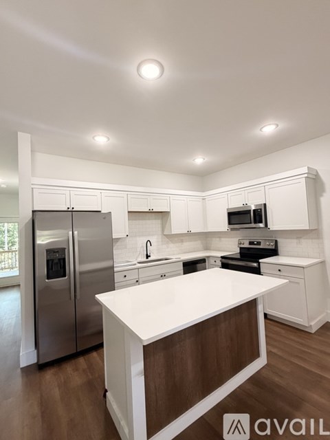A modern kitchen with white cabinets and a wooden island.