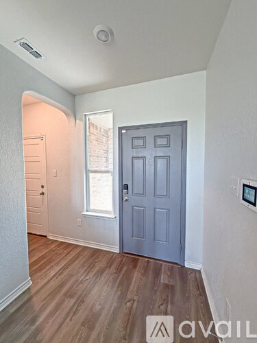 A room with a grey door and wooden flooring.