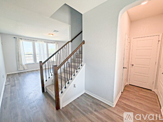 A spacious room with a staircase leading to the upper floor.