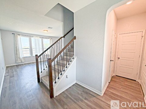 A spacious room with a staircase leading to the upper floor.