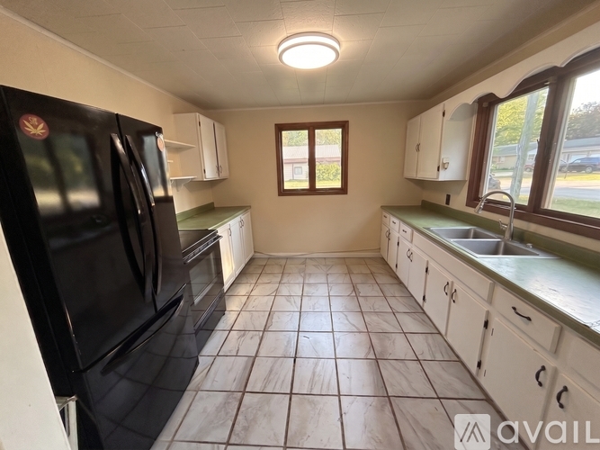 A kitchen with black appliances and white cabinets.