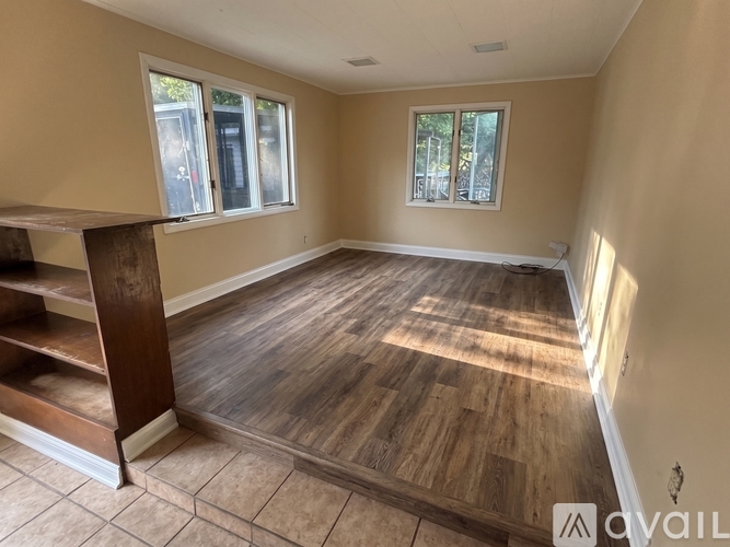 A room with wooden flooring and a window.
