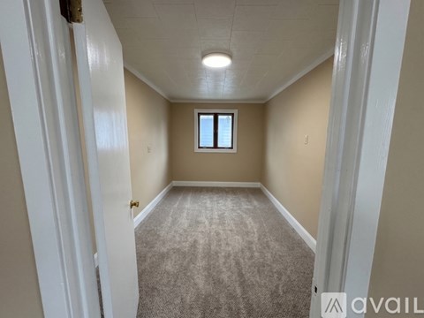 A room with a carpeted floor and a window.