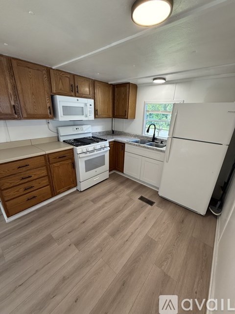 A kitchen with wooden cabinets and a white fridge.
