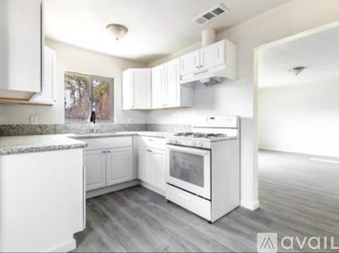A kitchen with white cabinets and appliances.