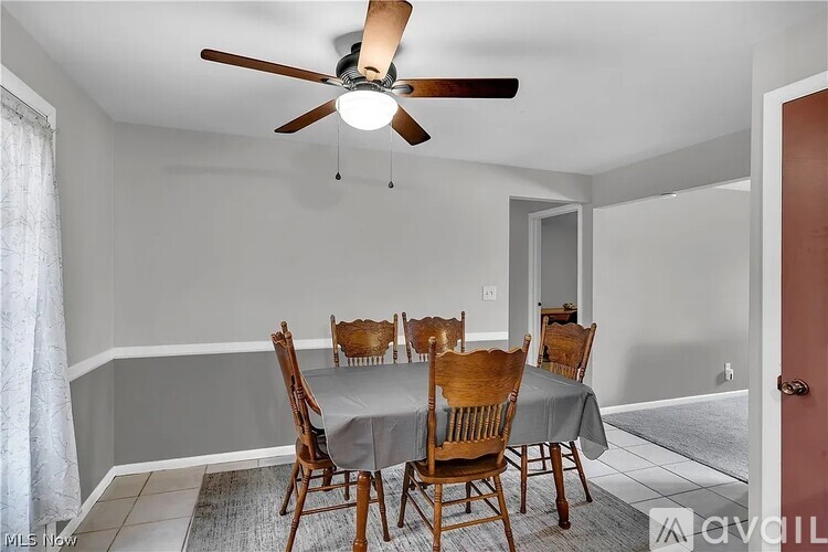 A dining room with a table and chairs.