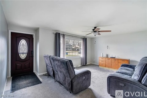 A living room with grey couches and a ceiling fan.
