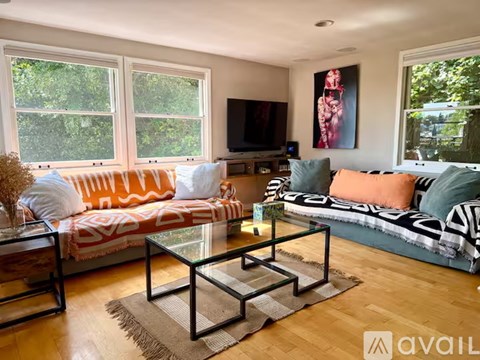 A living room with a sofa, a coffee table, and a television.