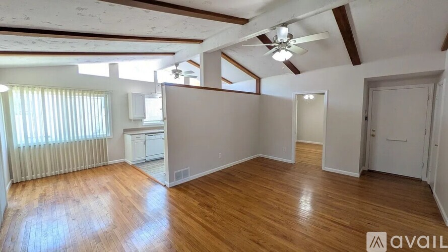 A room with wooden floors and a ceiling fan.