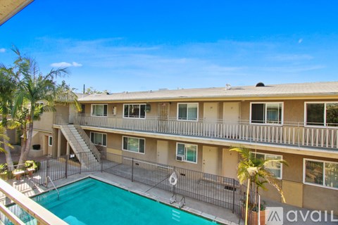 A large apartment complex with a pool and palm trees.