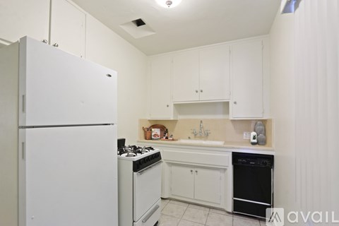 A kitchen with white appliances and cabinets.