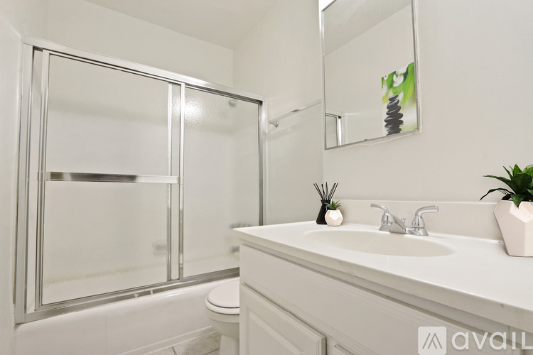 A bathroom with a white sink and a large mirror.