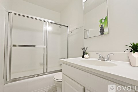 A bathroom with a white sink and a large mirror.
