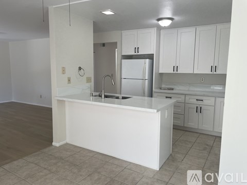 A kitchen with white cabinets and a white island.