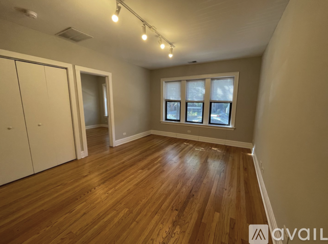 A room with wooden flooring and a window showing a snowy landscape outside.