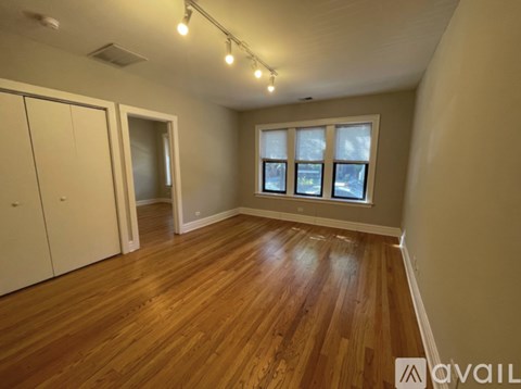 A room with wooden flooring and a window showing a snowy landscape outside.