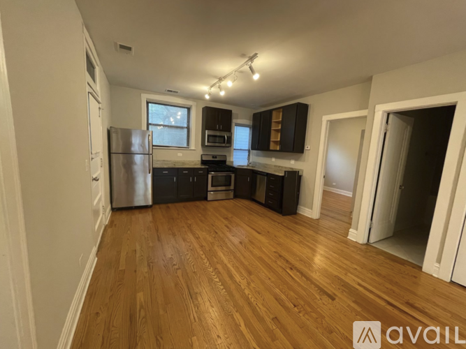 A kitchen with wooden floors and a refrigerator.