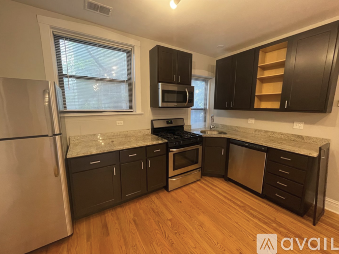 A kitchen with a refrigerator, oven, and microwave.