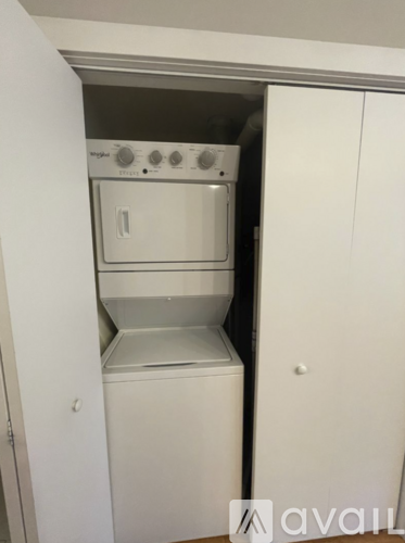 A white oven and microwave are installed in a kitchen cabinet.