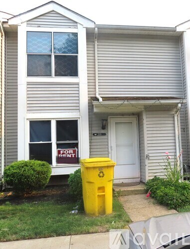 A house with a "For Rent" sign on the window.