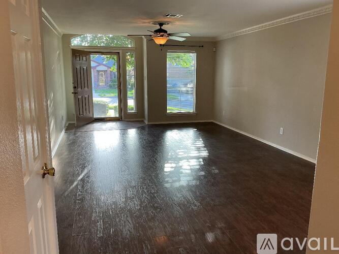 A room with a ceiling fan and sliding glass doors.