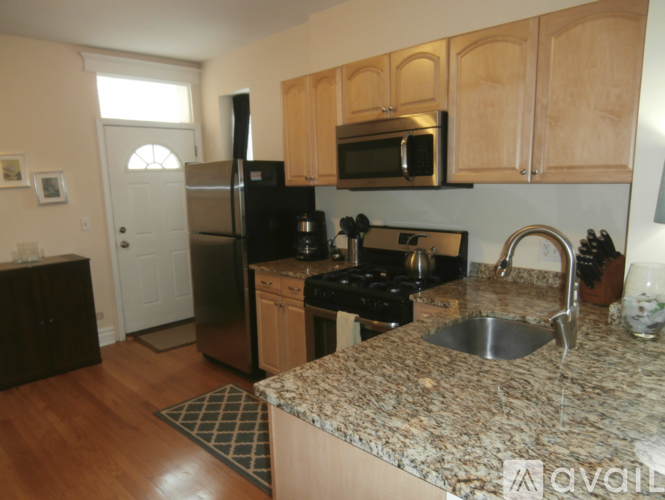 A kitchen with a granite counter top and stainless steel appliances.