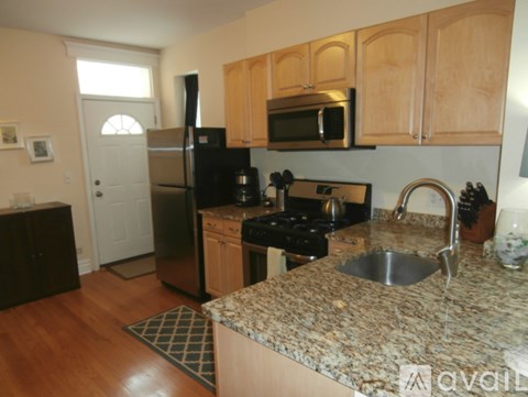 A kitchen with a granite counter top and stainless steel appliances.