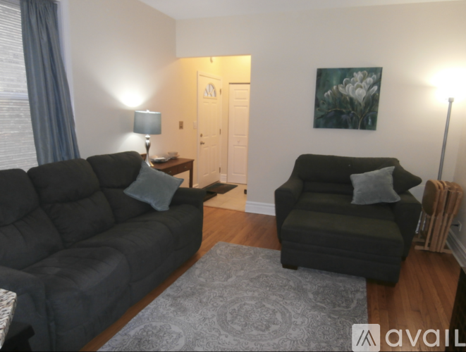 A living room with a grey couch and a black chair.