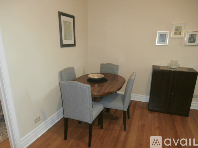 A dining room with a wooden table and grey chairs.