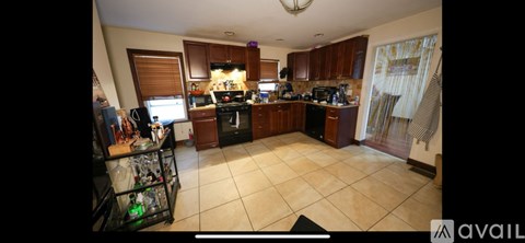 A kitchen with brown cabinets and a black stove top oven.