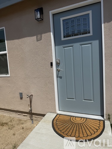 A grey door with a glass panel and a doorknob.