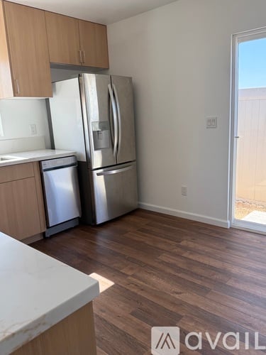 A kitchen with a white counter top and a refrigerator.