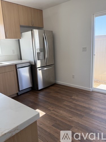 A kitchen with a white counter top and a refrigerator.