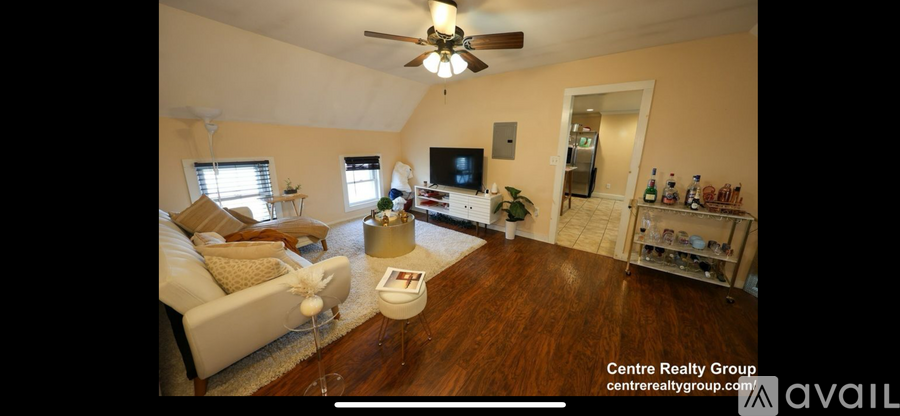 A living room with a couch, a television, and a bar area.