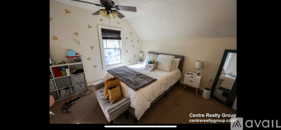 A bedroom with a bed, nightstand, and a ceiling fan.