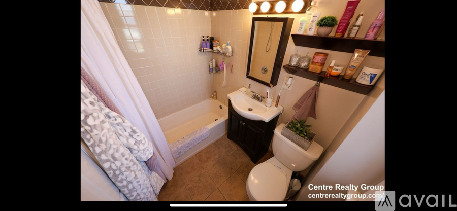 A bathroom with a toilet, sink, and a bathtub with a shower curtain.