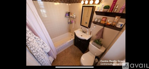 A bathroom with a toilet, sink, and a bathtub with a shower curtain.