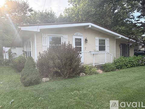 A house with a well-maintained lawn and a white picket fence.
