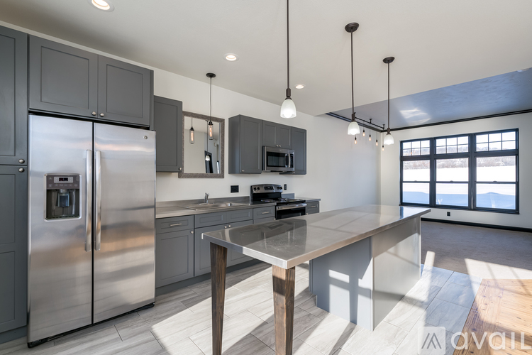 A modern kitchen with a large island and stainless steel appliances.