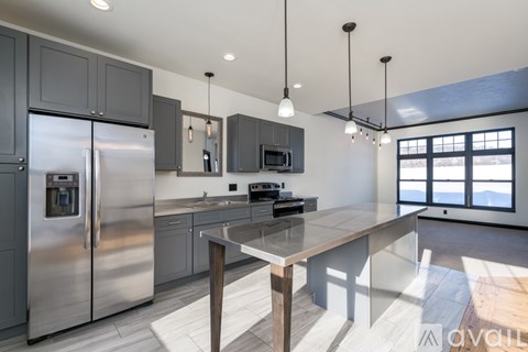A modern kitchen with a large island and stainless steel appliances.
