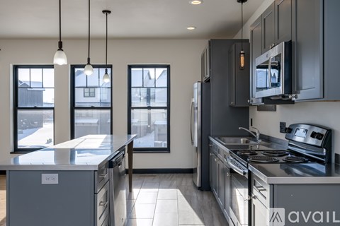 A modern kitchen with stainless steel appliances and a large island.
